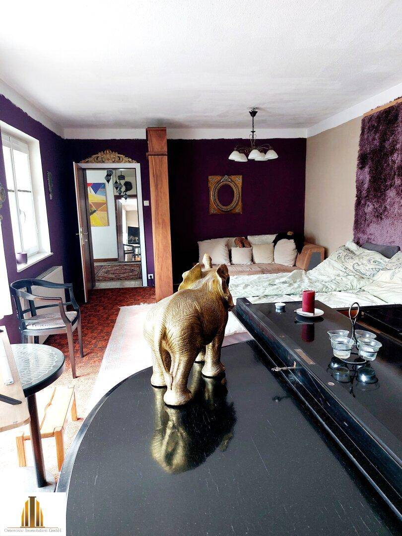 Schlafzimmer mit auffälligen violetten Wänden, einem Flügel und traditioneller Dekoration.