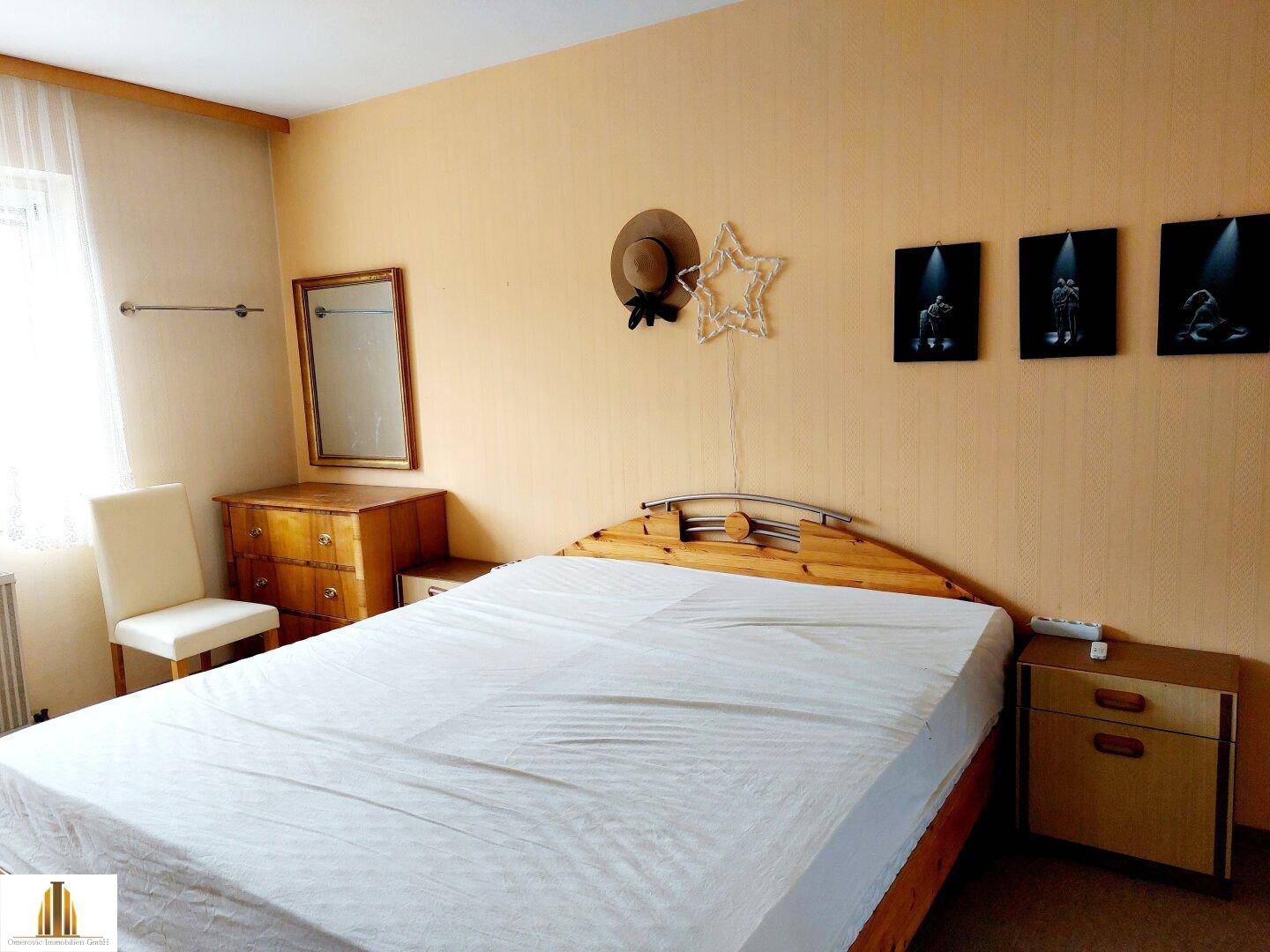 Schlafzimmer mit hellem Teppichboden, großen Fenstern und Einbauschränken.