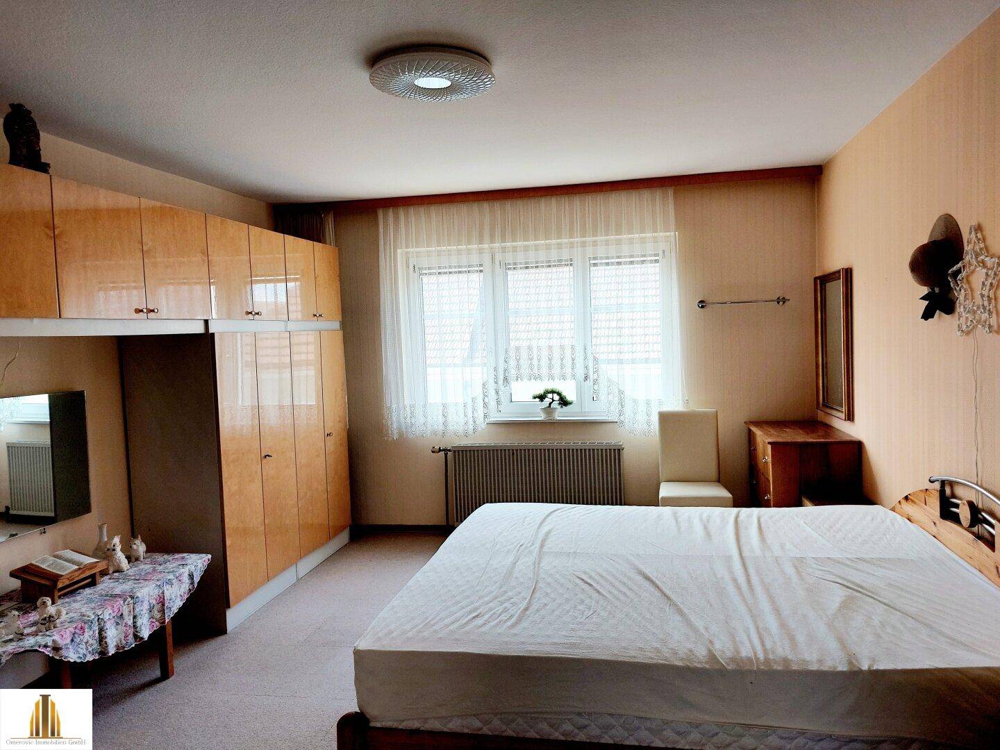 Schlafzimmer mit hellem Teppichboden, großen Fenstern und Einbauschränken.