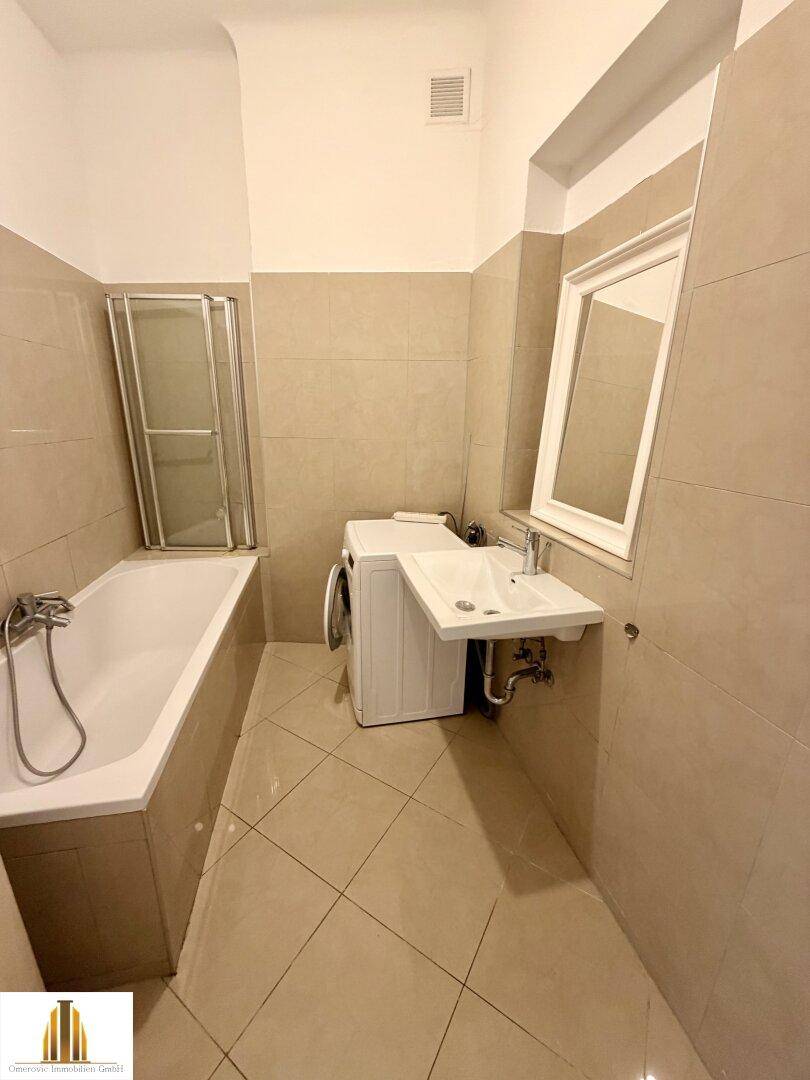 Modernes Badezimmer mit Badewanne, Duschkabine, Waschbecken und Waschmaschine.