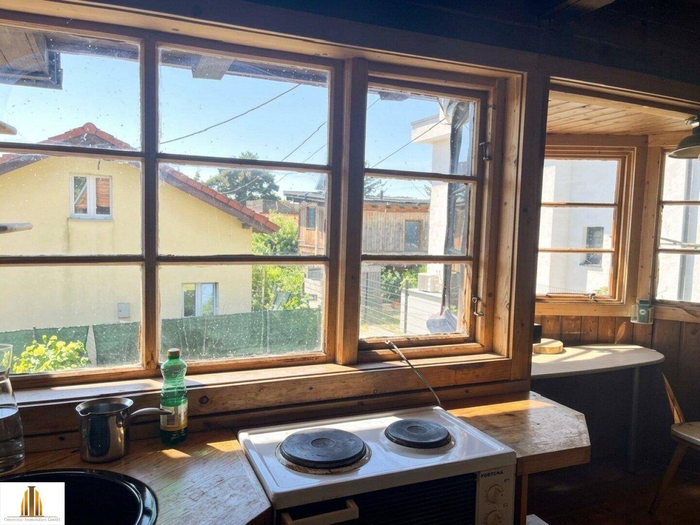 Küchenbereich mit Fenster und Blick auf die umliegenden Häuser und Gärten.