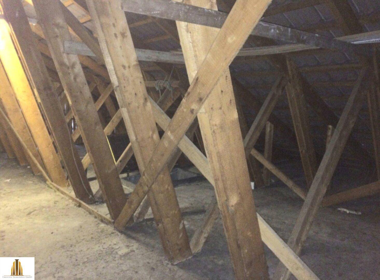 Unausgebauter Dachboden mit sichtbaren Holzbalken und Dachkonstruktion.