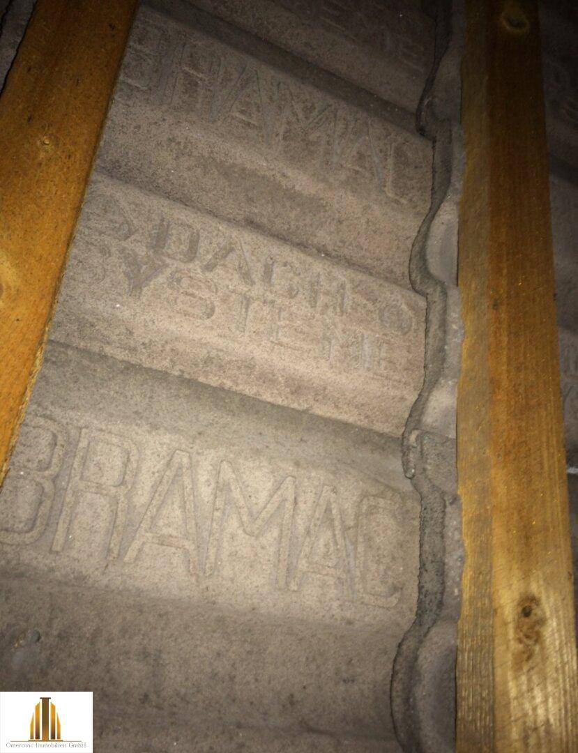 Detailansicht der Dachkonstruktion mit sichtbaren Ziegeln und Holzbalken.