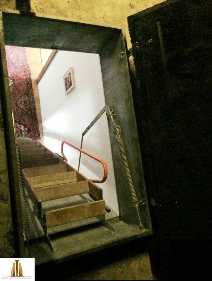 Zugang zum Keller über eine Klappe und eine steile Holztreppe.