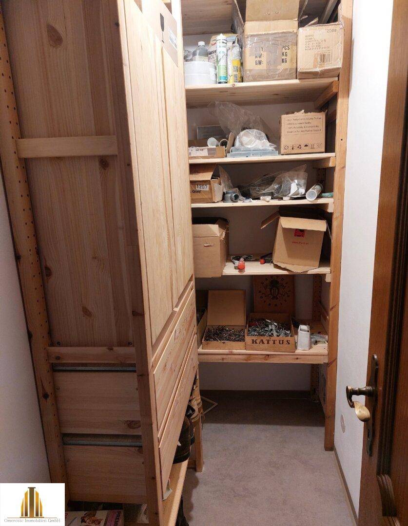 Praktischer Abstellraum mit Holzregalen und Stauraum für Haushaltsgegenstände.