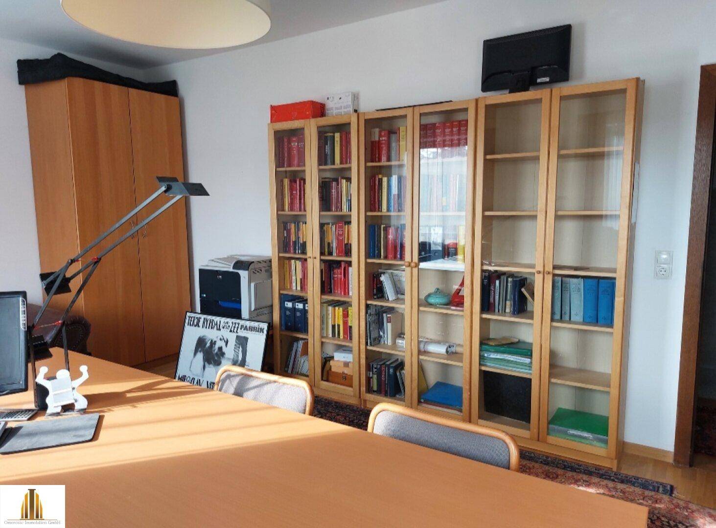 Büro mit Bücherregalen, Schreibtisch und einem Sofa, ideal für Home-Office.