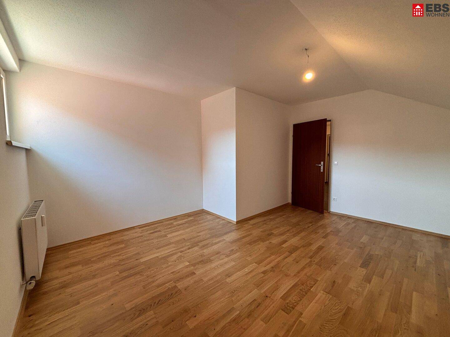 Heller Raum mit Holzboden und weiß gestrichenen Wänden, bereit für neue Bewohner.