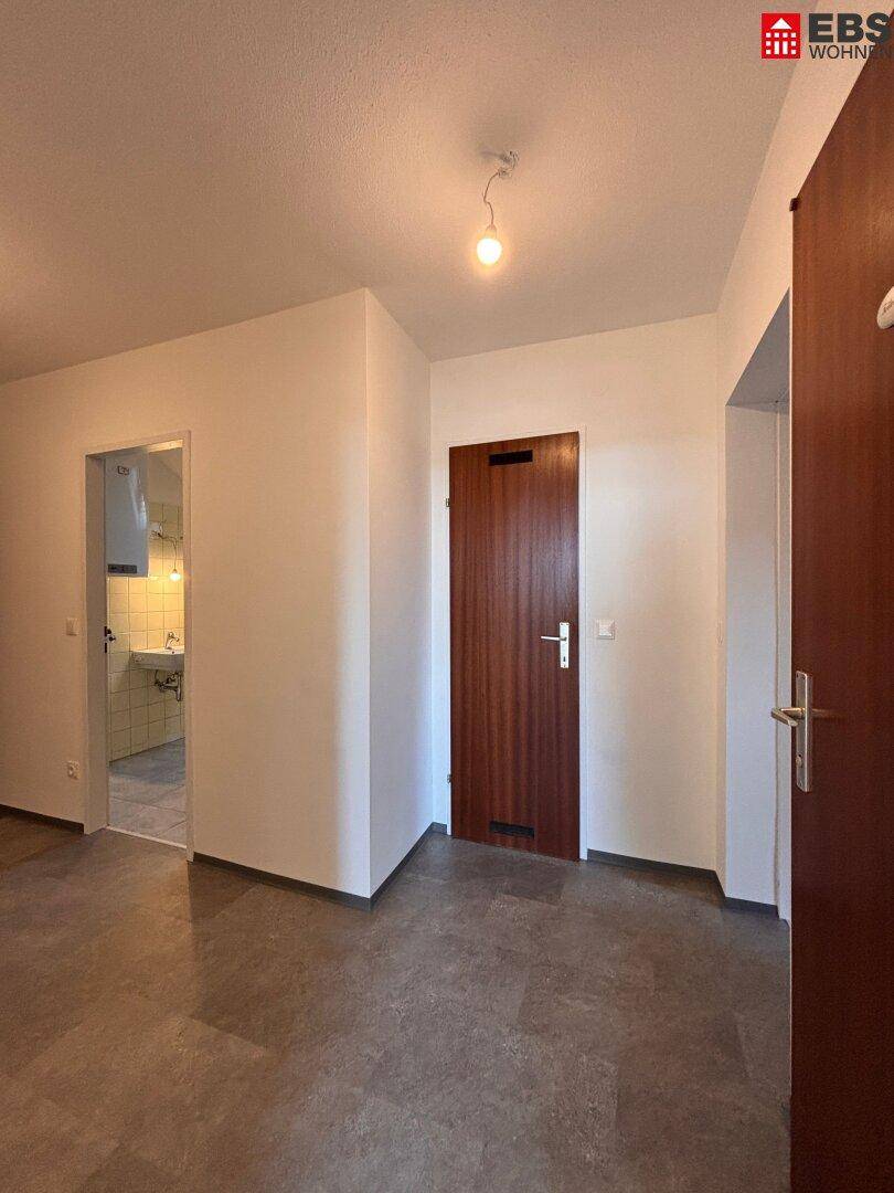 Eingangsbereich mit Fliesenboden und Zugang zu verschiedenen Zimmern, inklusive Badezimmer.