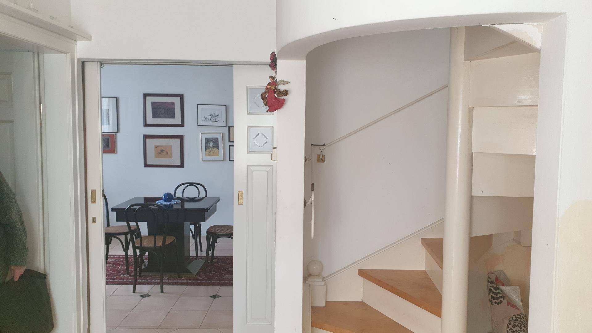 Heller Flur mit eleganter Wendeltreppe und Blick in den angrenzenden Essbereich.