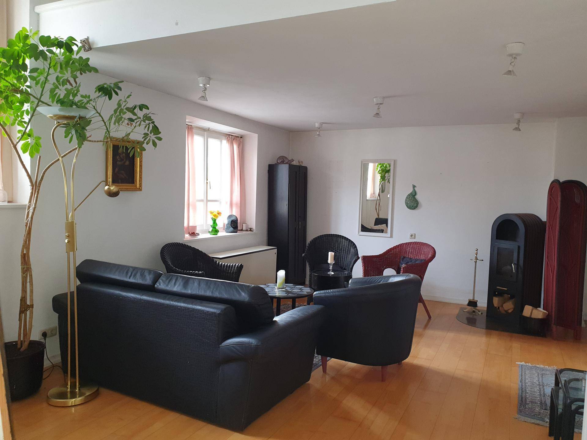 Helles Wohnzimmer mit bequemen Sofas, Holzboden und dekorativen Pflanzen, ideal zum Entspannen.