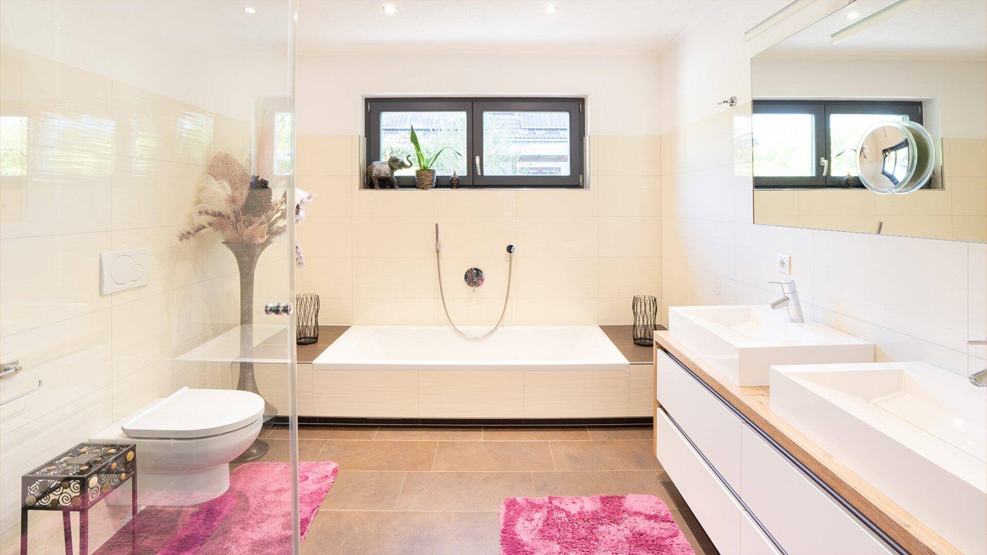 Modernes Badezimmer mit Badewanne, Doppelwaschbecken und Fenster für Tageslicht.