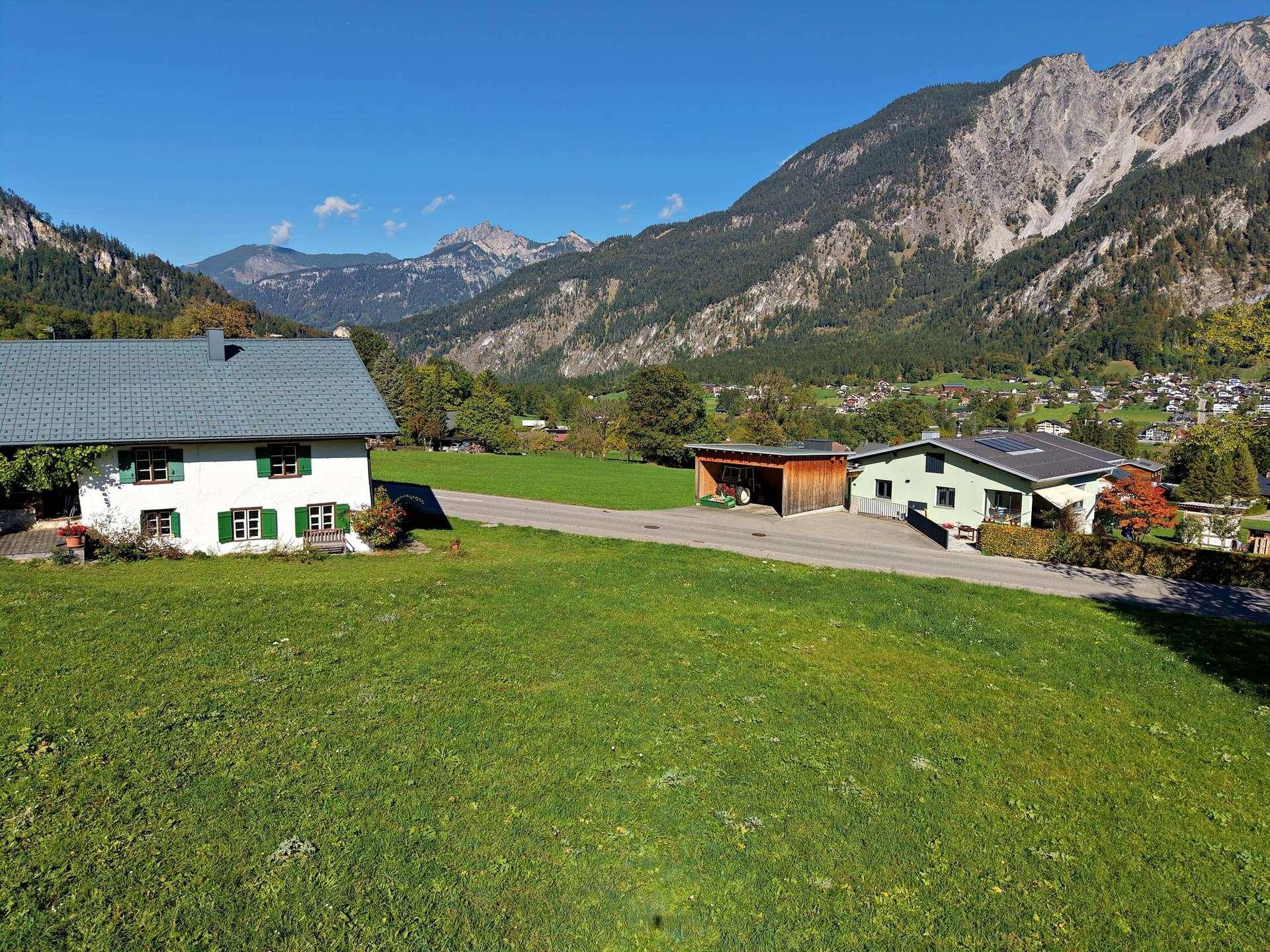 Zwei Wohnhäuser in ländlicher Umgebung mit weitem Blick auf die umliegenden Berge.