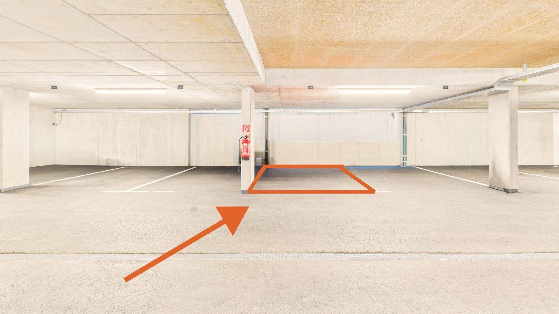 Geräumige Tiefgarage mit markierten Stellplätzen und Brandschutzvorrichtungen.