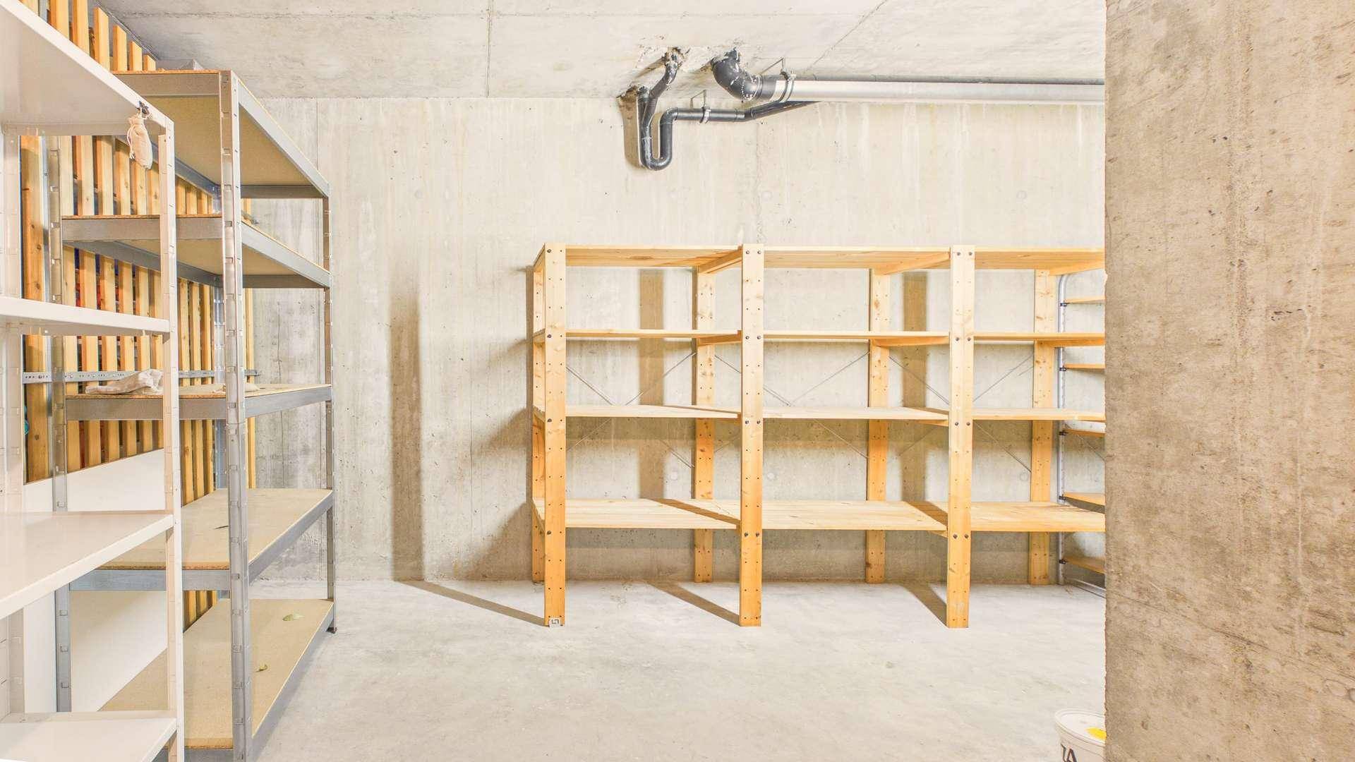 Großer Abstellraum im Keller mit verschiedenen Regalsystemen und Betonboden.
