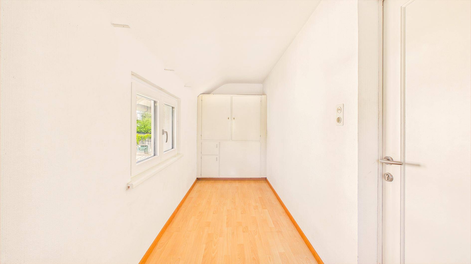 Heller Flur mit Parkettboden und Einbauschrank, bietet praktischen Stauraum.