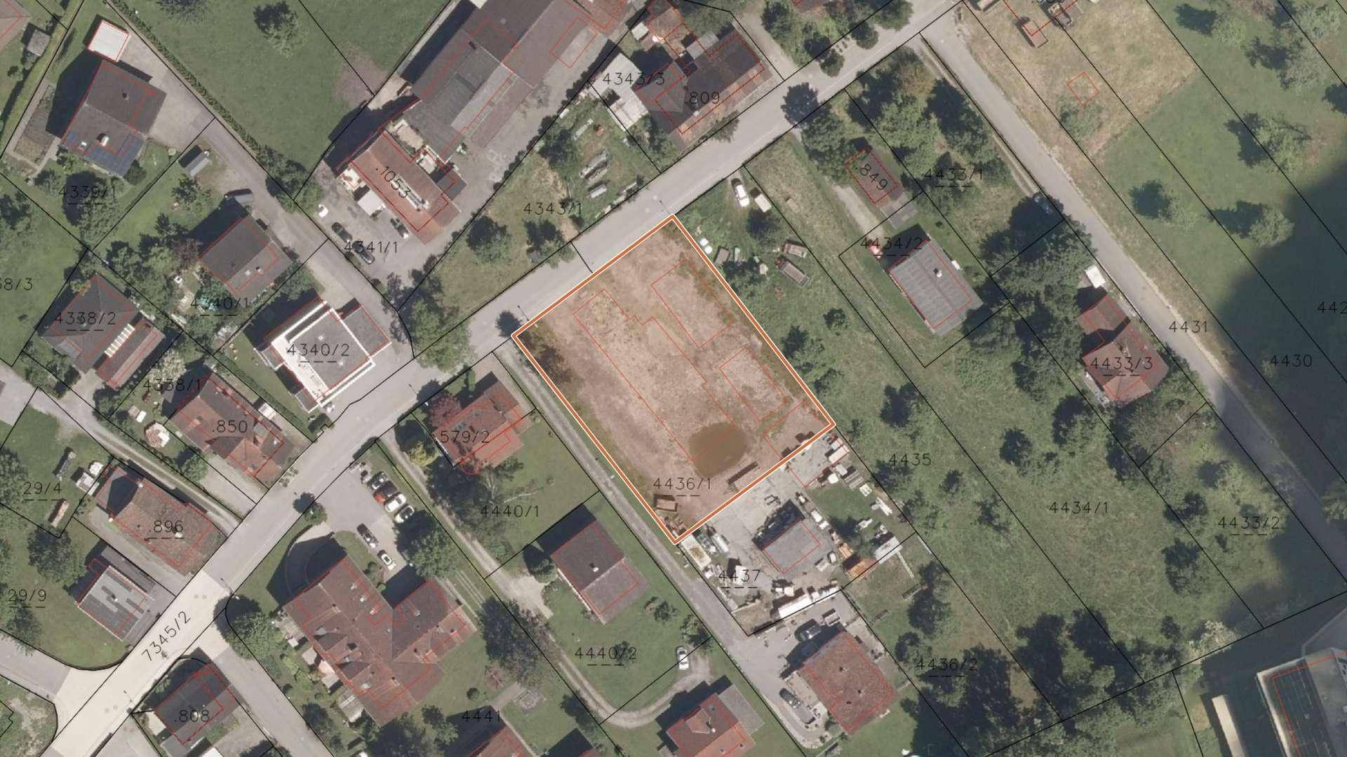 Satellitenaufnahme des Grundstücks mit orangefarbener Umrandung, umgeben von Wohnhäusern und Straßen.