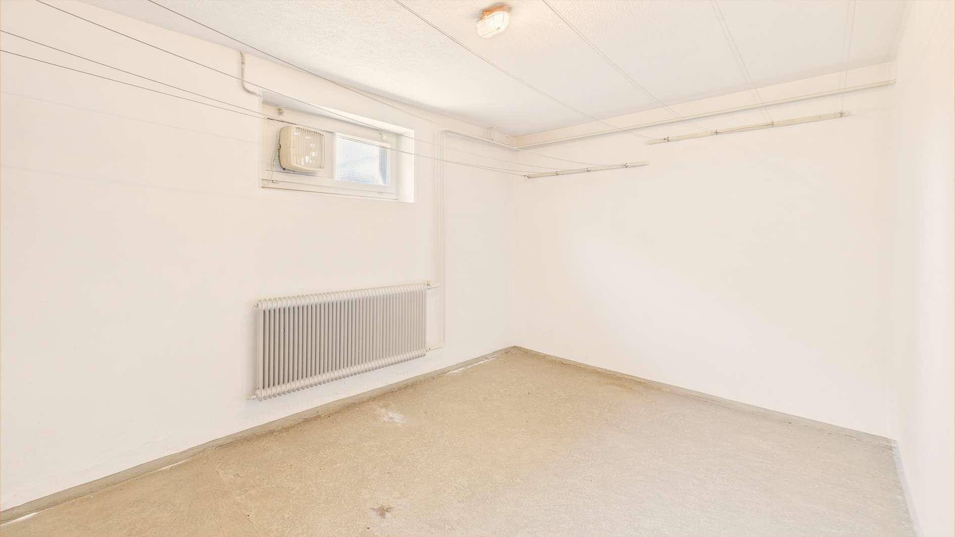 Heller Hauswirtschaftsraum mit Fenster, Heizkörper und Wäscheleinen zum Trocknen.