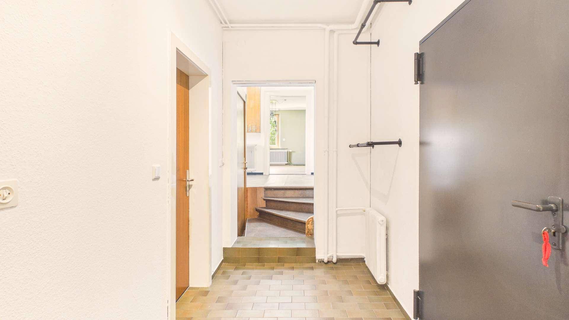 Eingangsbereich mit Fliesenboden und Treppenaufgang zu den oberen Etagen.