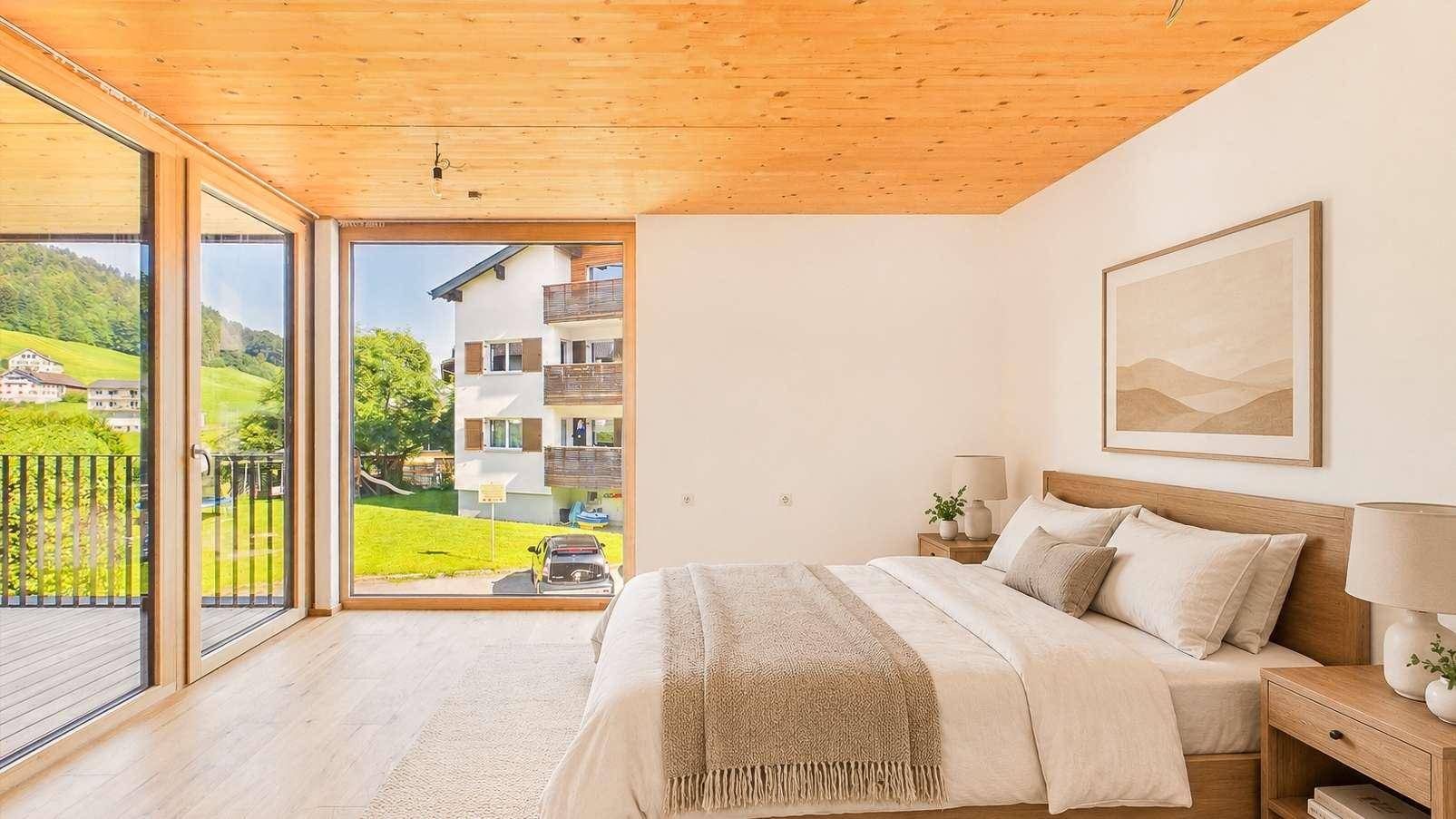 Helles Schlafzimmer mit Doppelbett, Holzboden und großem Fenster mit Balkonzugang.