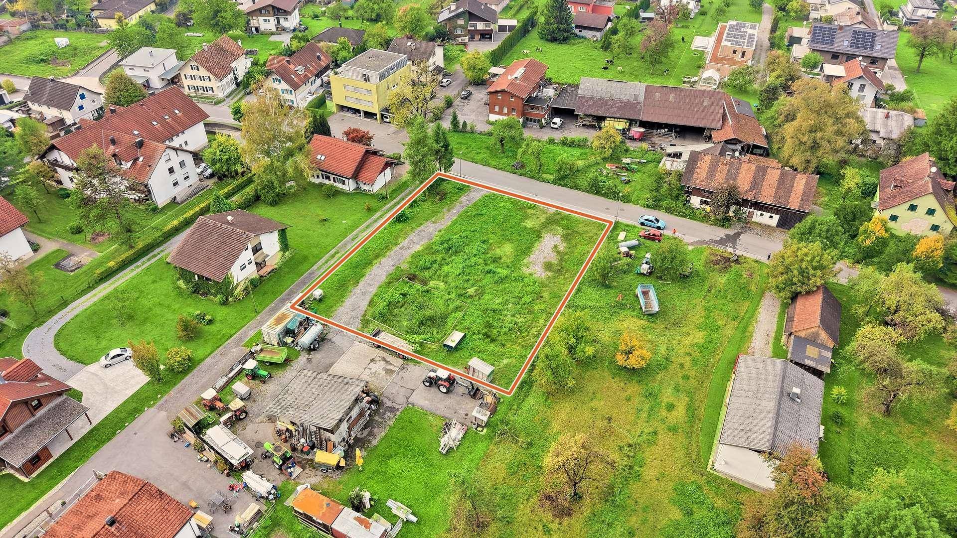 Panoramablick aus der Luft auf ein großes, grünes Grundstück, eingebettet in eine Wohnsiedlung mit viel Natur.