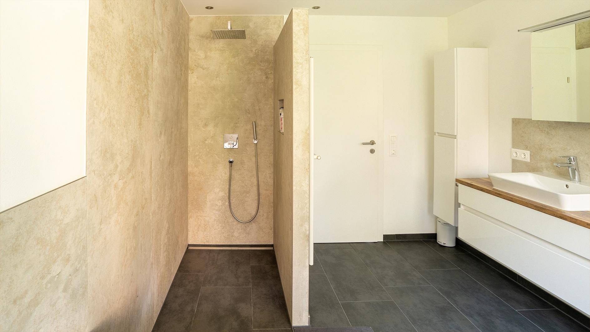 Modernes Badezimmer mit begehbarer Dusche, Regendusche und Waschtisch mit Holzplatte.