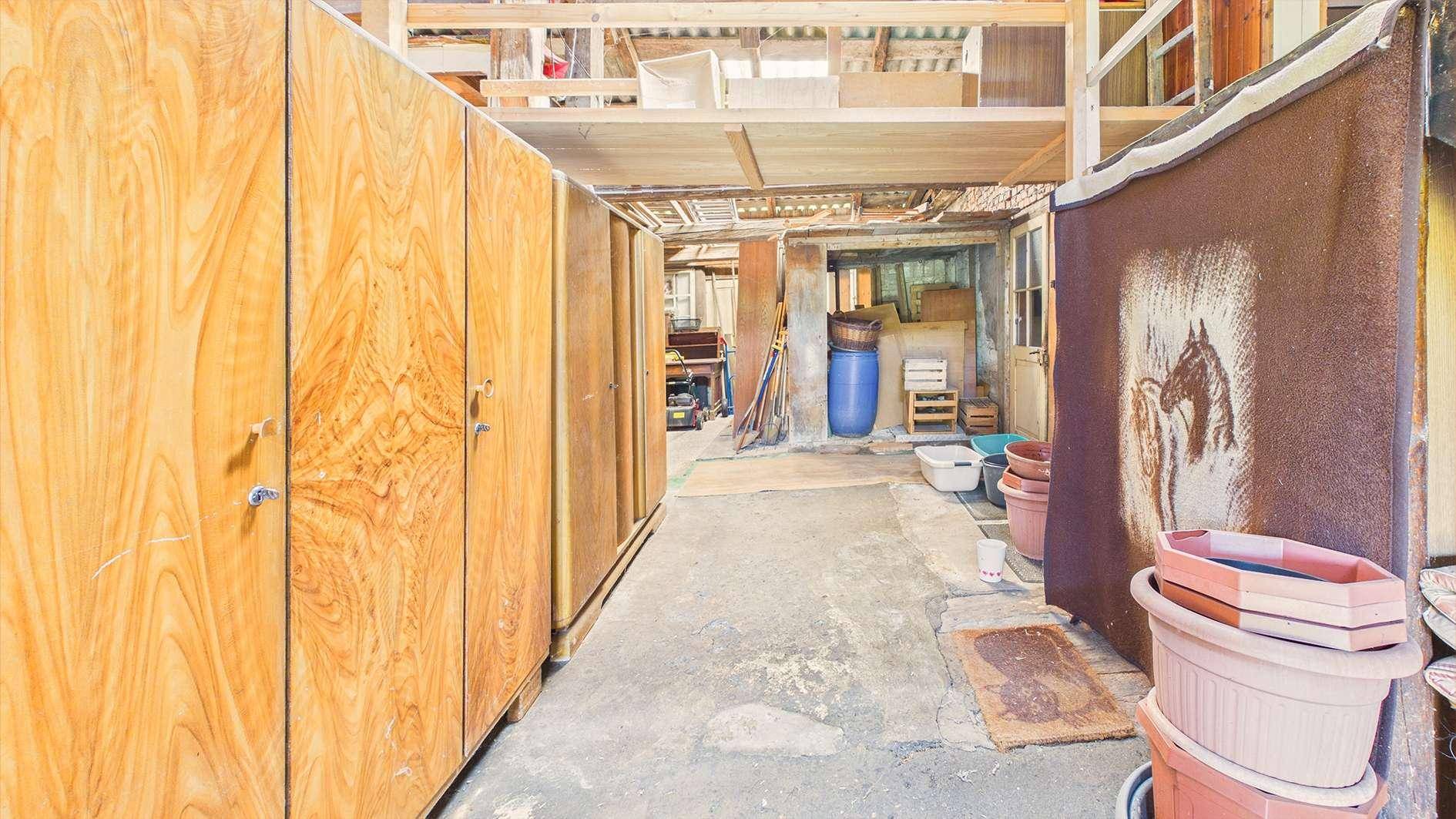 Geräumiger Lagerbereich im Keller mit Holzschränken und Betonboden.