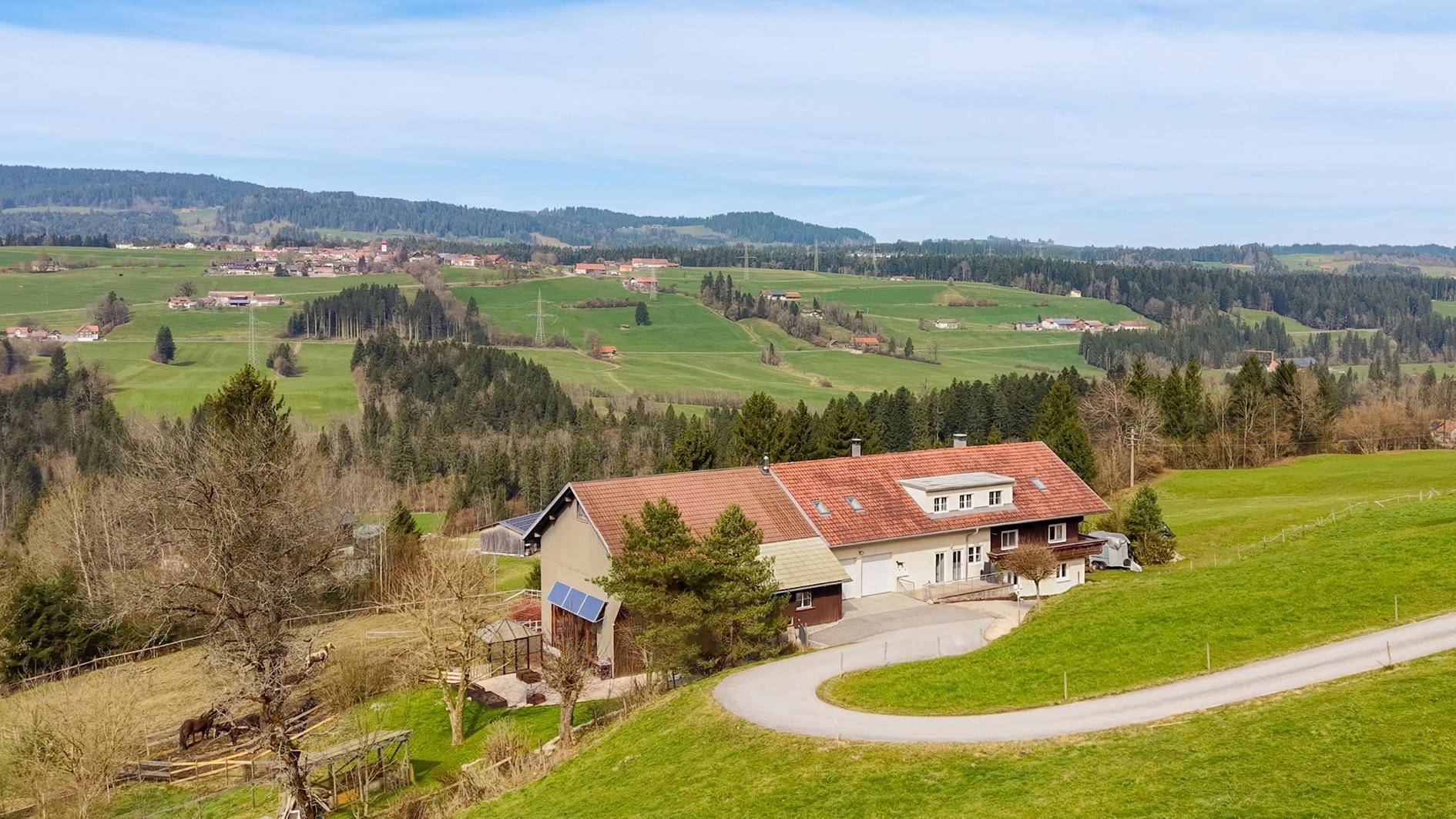 Panoramablick auf das Anwesen und die umliegende ländliche Gegend mit Wäldern und Feldern.