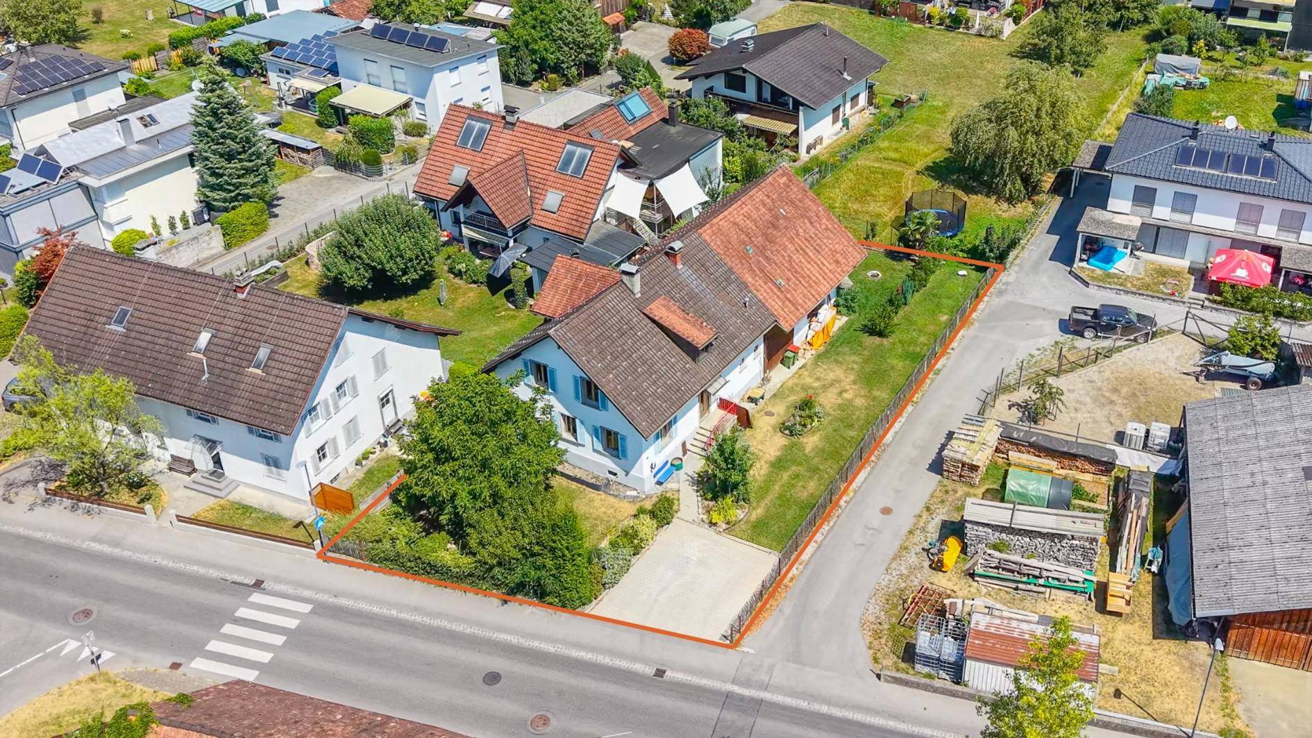 Luftaufnahme des Anwesens mit Garten und umliegender Bebauung, rot umrandet.