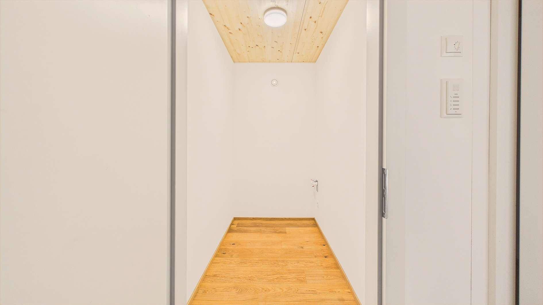 Kleiner Abstellraum mit Holzboden und Holzlamellendecke, ideal für zusätzlichen Stauraum im Haus.