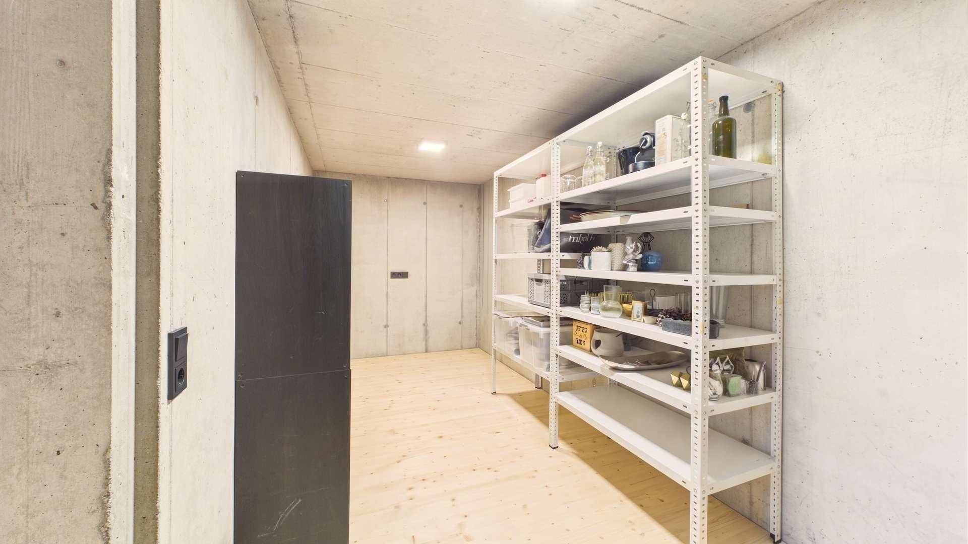 Heller Kellerraum mit Regalen für Lagerung und einem Holzboden.