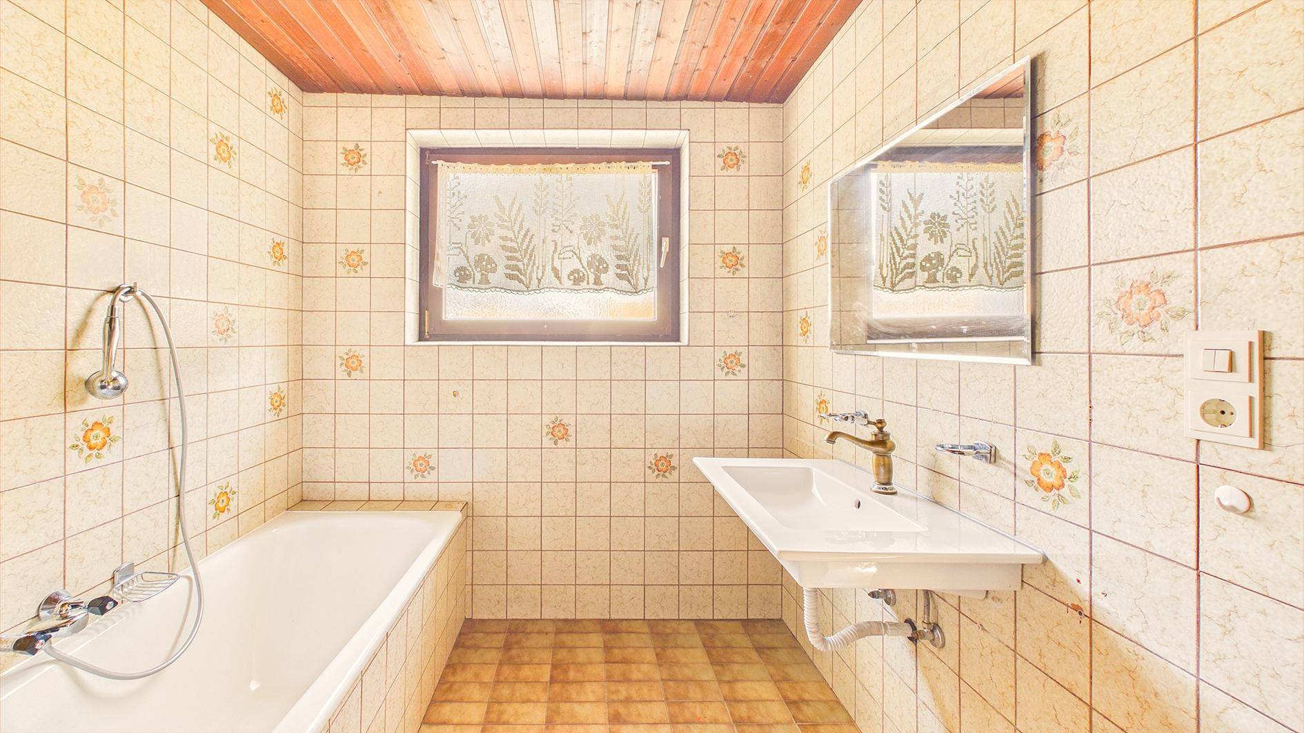 Traditionelles Badezimmer mit gemusterten Fliesen, Holzdecke und Badewanne mit Duschfunktion.