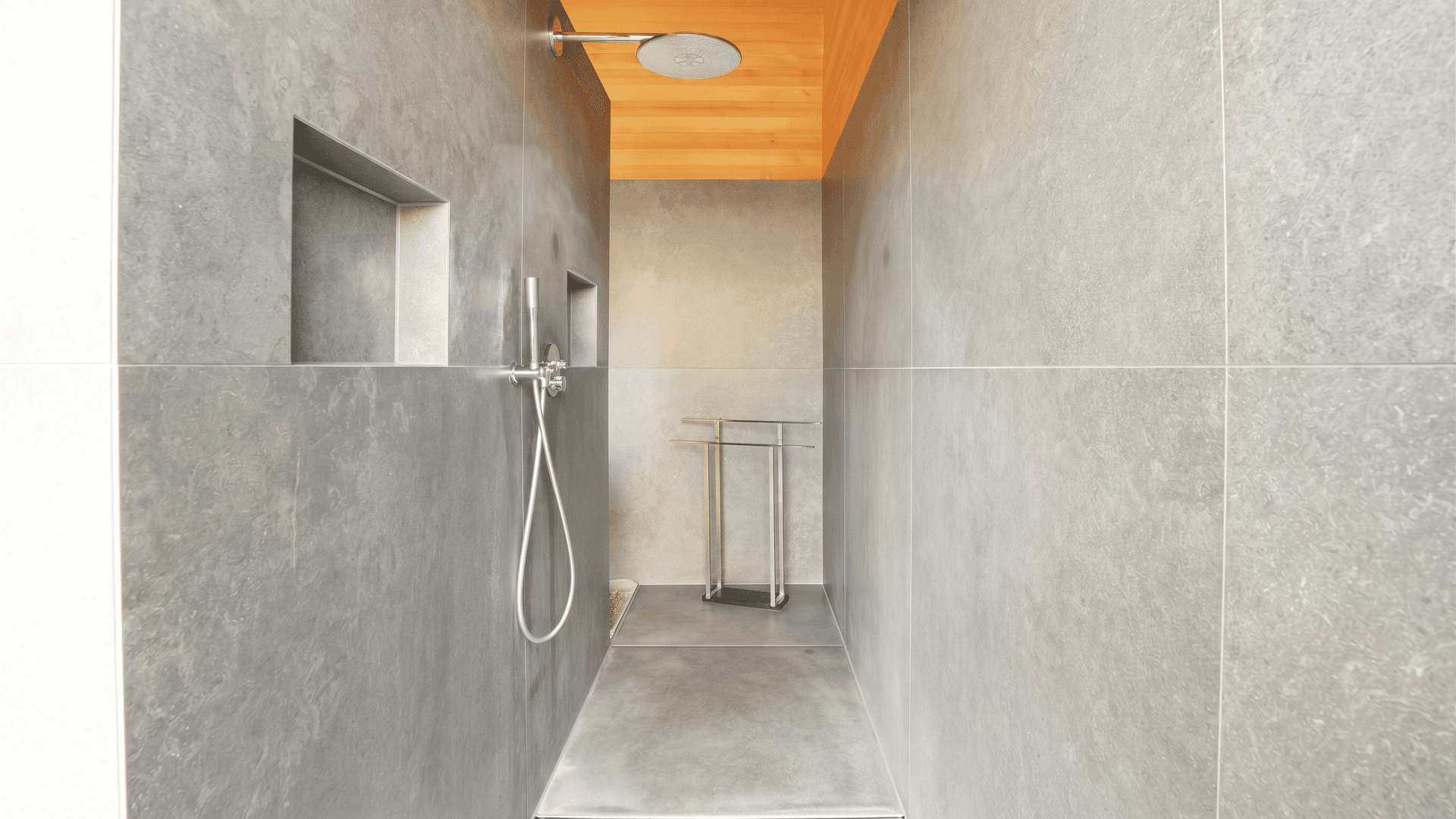 Geräumige begehbare Dusche mit grauen Fliesen und moderner Regendusche.