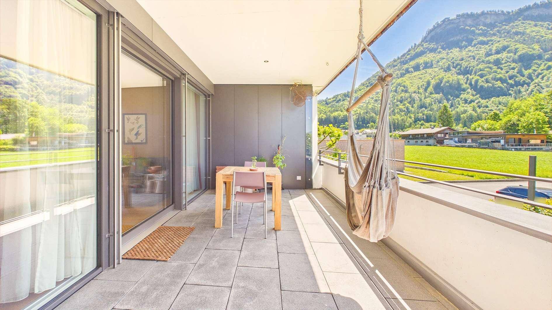 Geräumiger Balkon mit Bergblick, Sitzgelegenheiten und Hängematte.