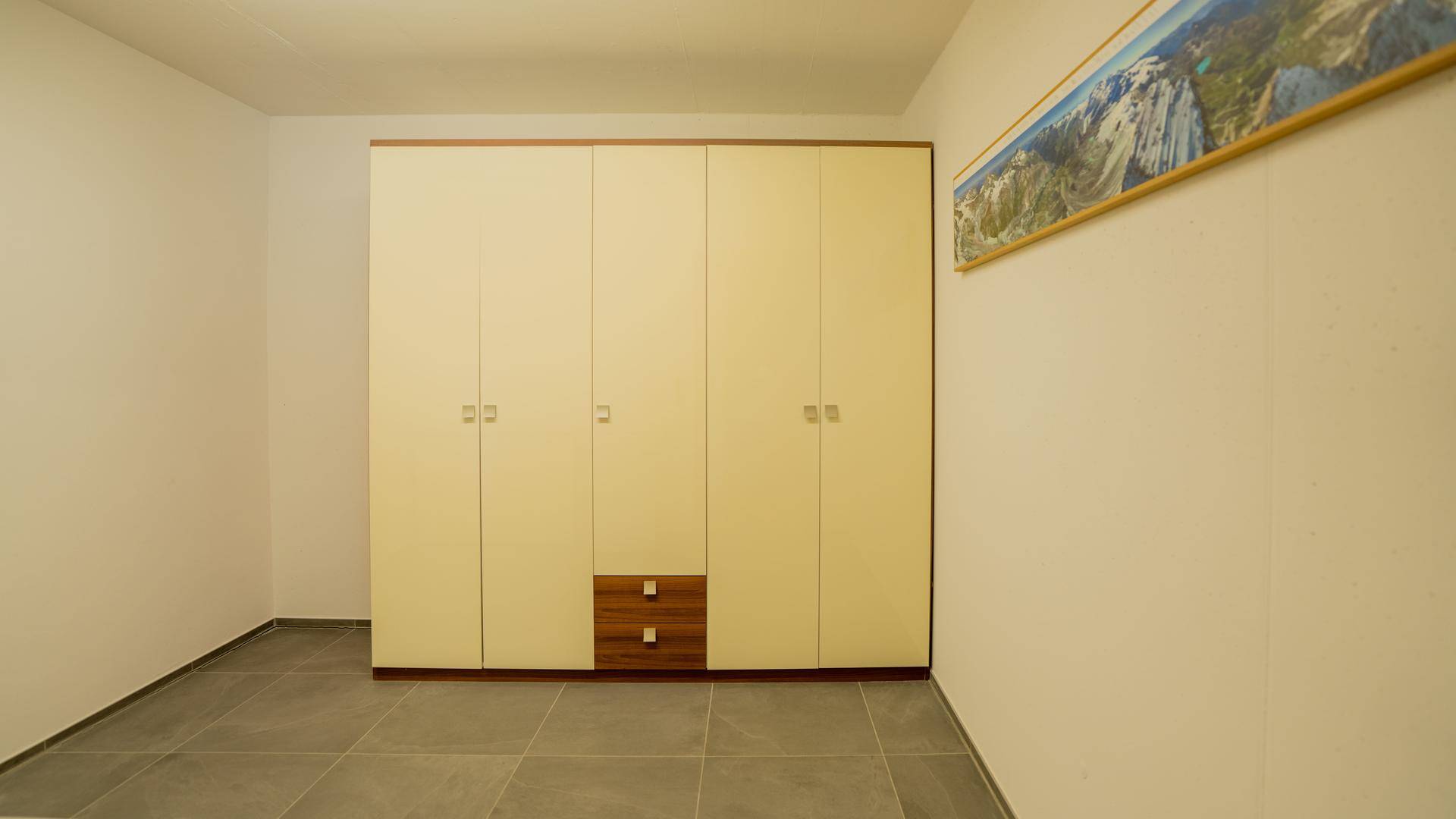 Abstellraum mit großem Einbauschrank und Fliesenboden für zusätzlichen Stauraum.