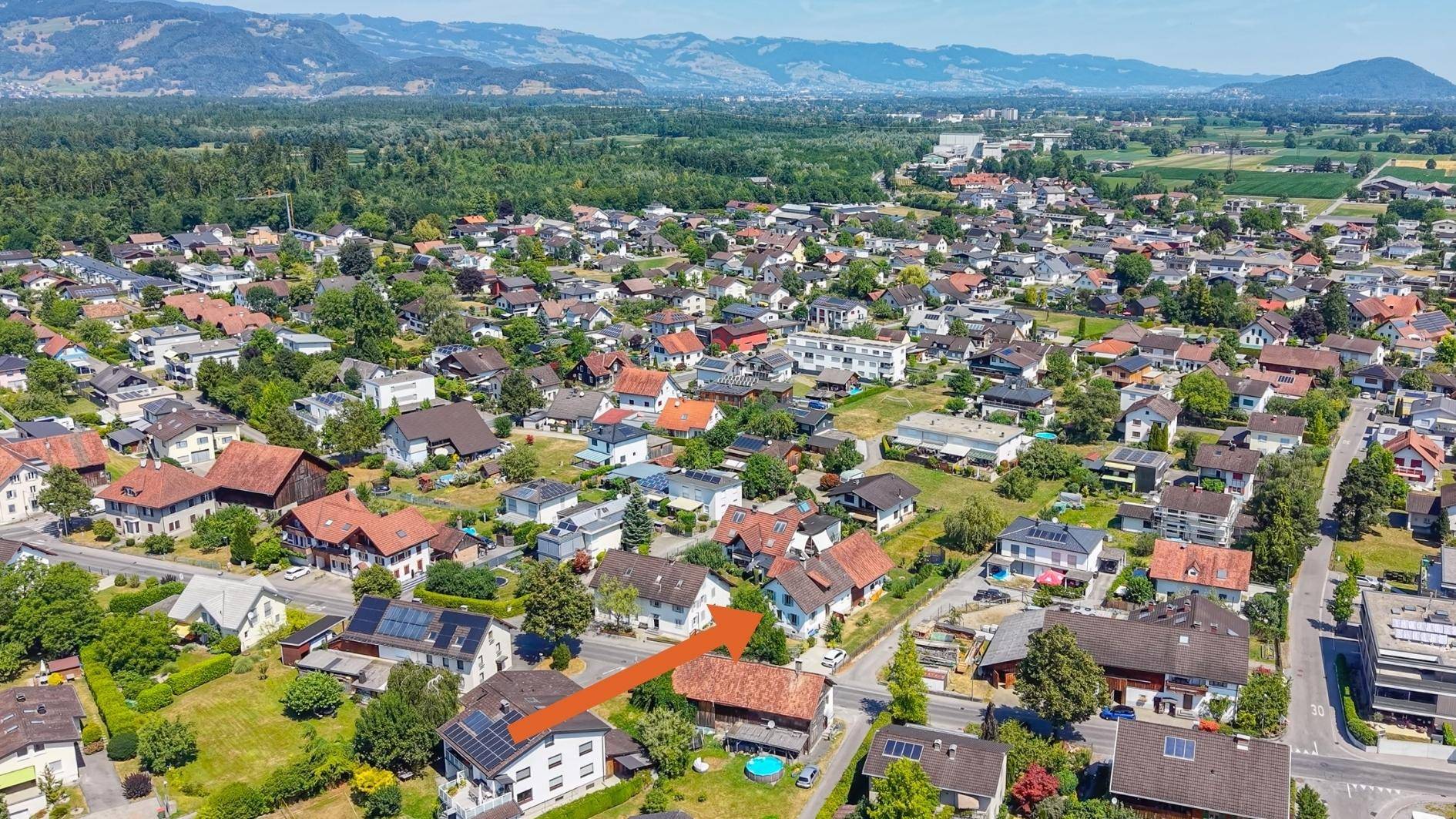 Weitläufige Luftaufnahme der Wohngegend mit Bergblick und markiertem Objekt.