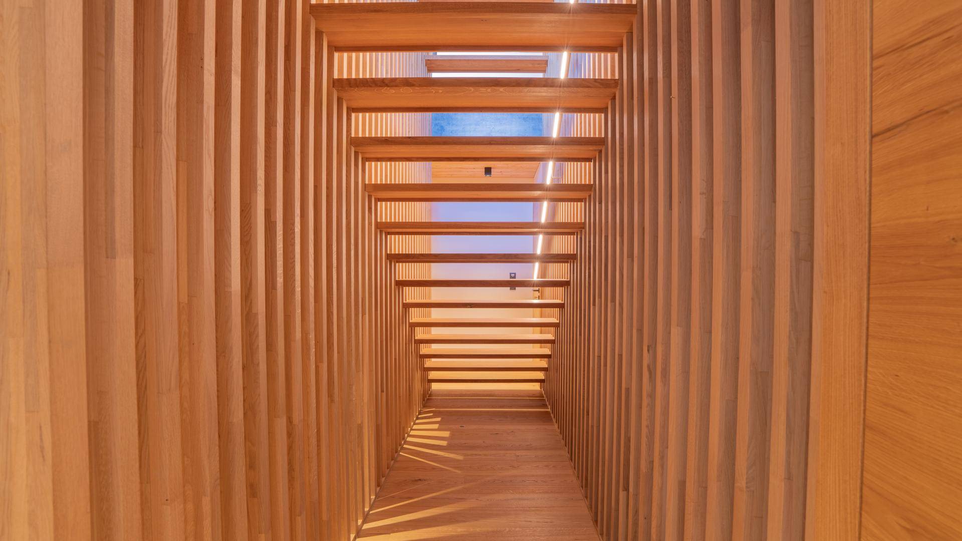 Heller Flur mit Holzverkleidung und vertikalen Lamellen, die natürliches Licht hereinlassen.