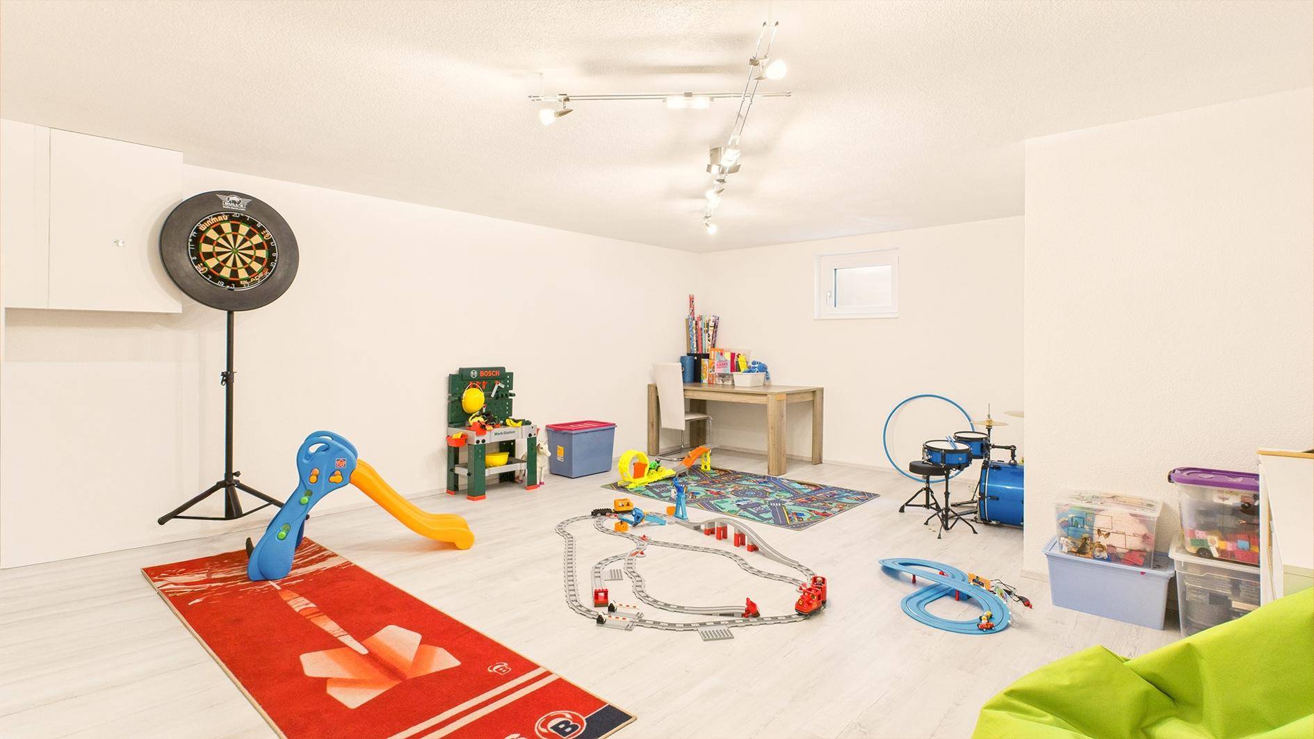 Geräumiger Hobbyraum im Keller, eingerichtet als Spielzimmer mit verschiedenen Spielsachen.