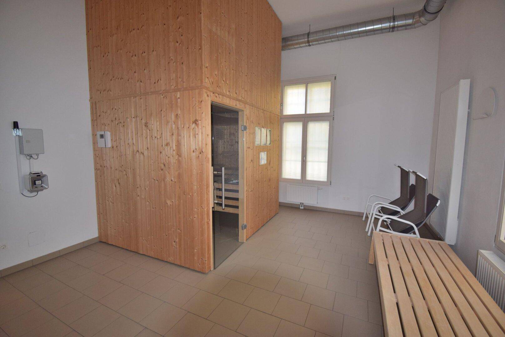 Entspannungsbereich mit einer modernen Holzsauna und Liegemöglichkeiten.