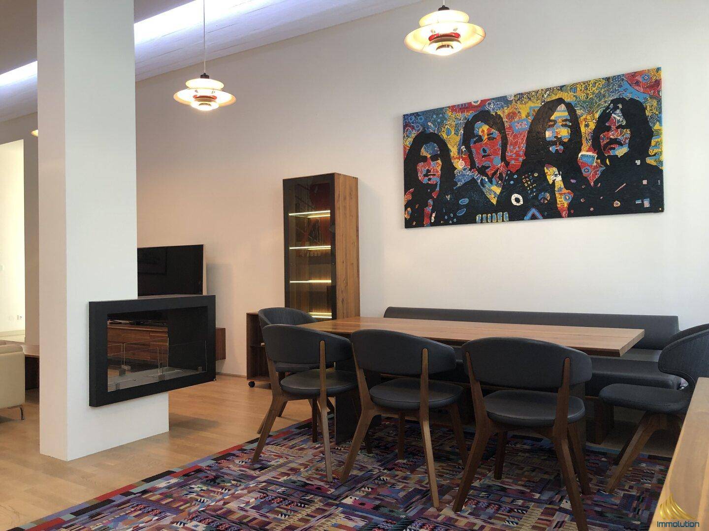 Heller Essbereich mit großem Tisch, bequemer Sitzbank und einem dekorativen Kamin.