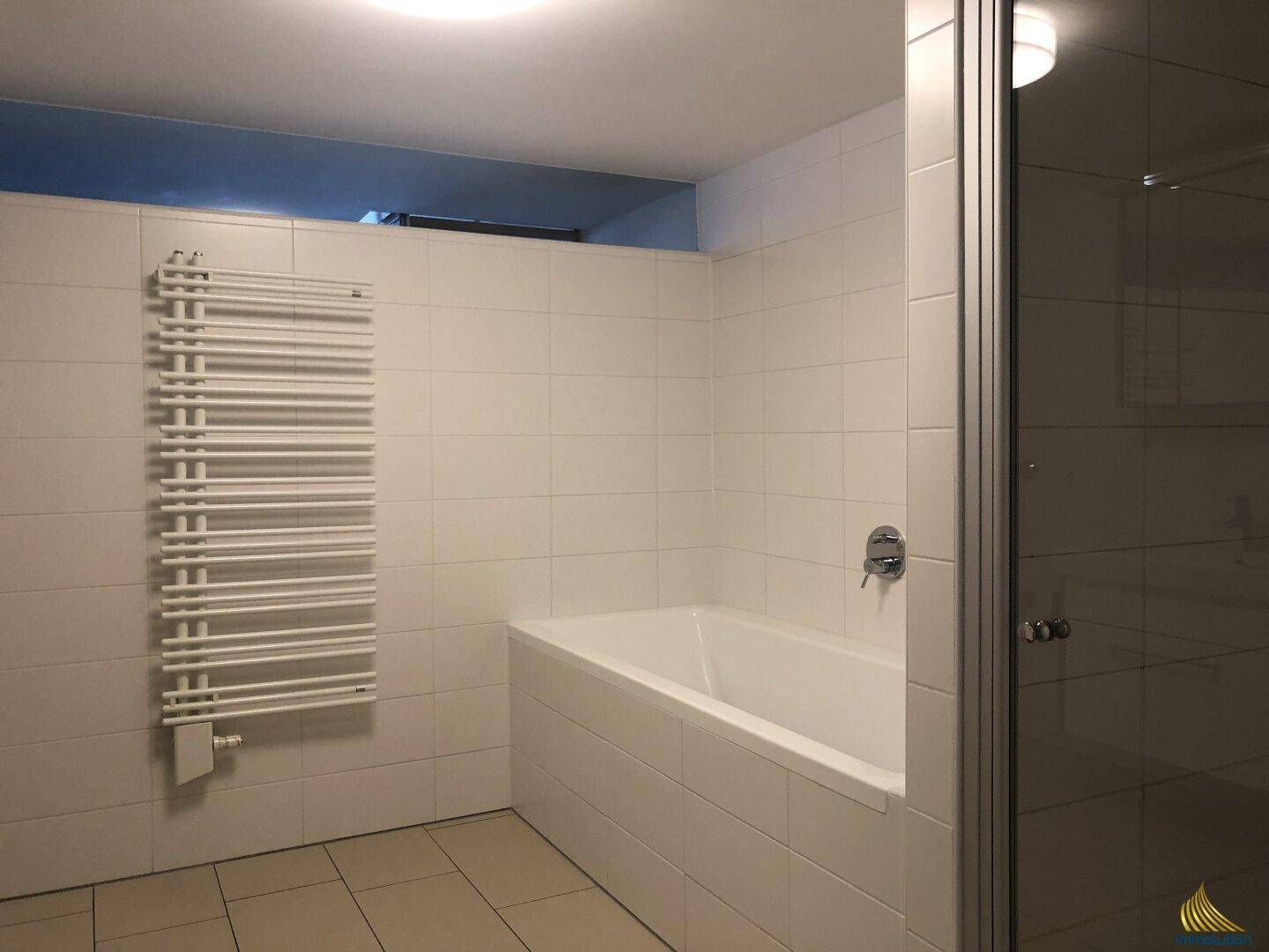 Badezimmer mit Badewanne, Duschkabine und einem praktischen Handtuchheizkörper.