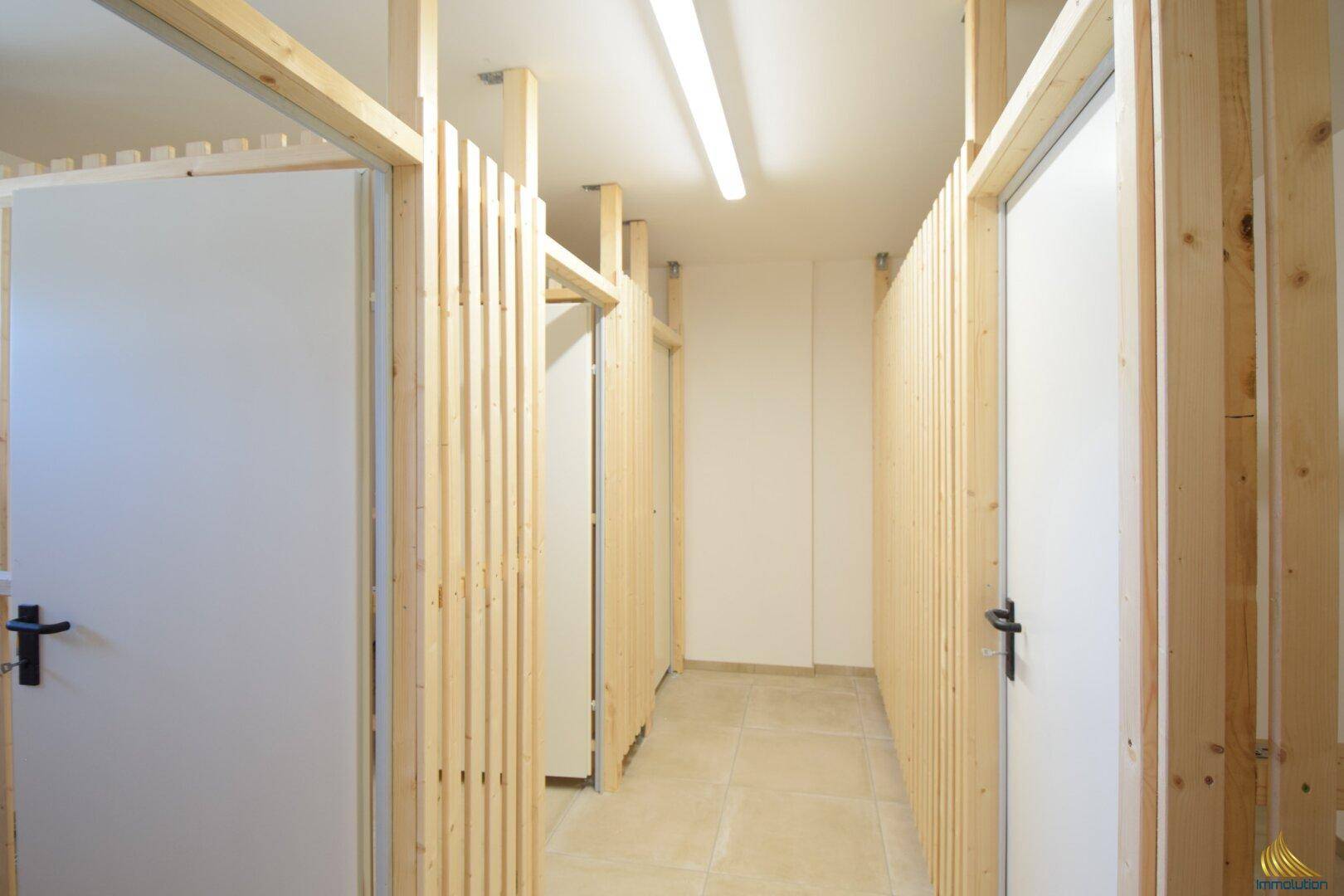 Abstellraum mit individuellen Holzverschlägen und Fliesenboden im Kellerbereich, praktisch und geräumig.