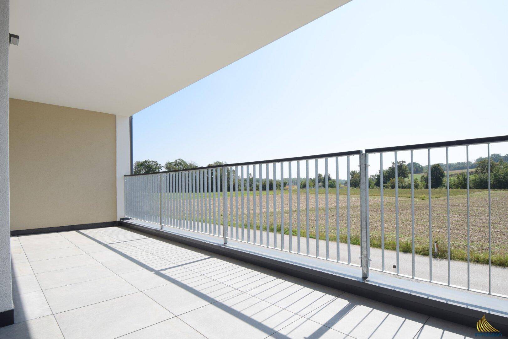 Geräumiger Balkon mit Fliesenboden und weitem Blick ins Grüne, ideal zum Entspannen.
