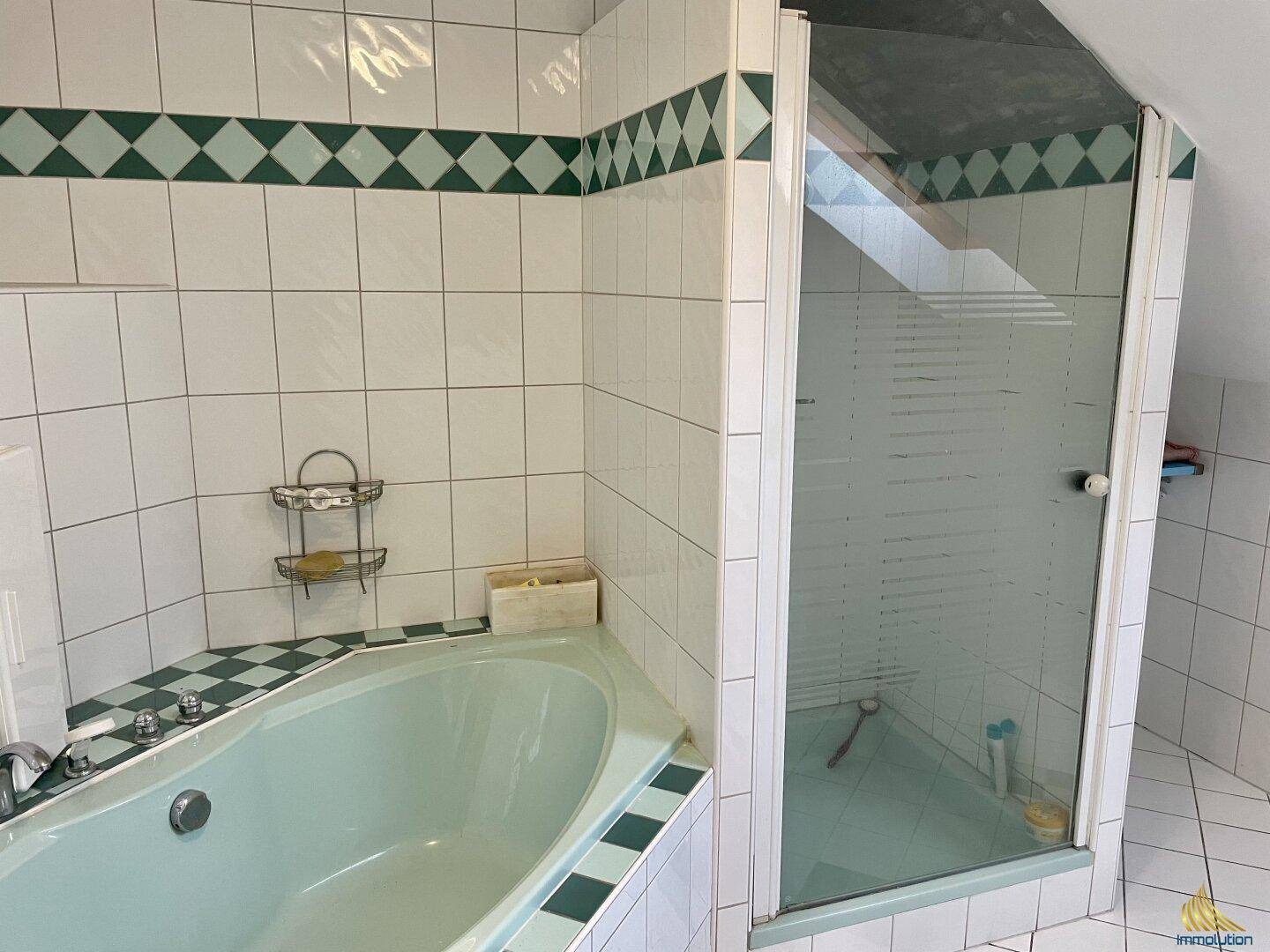 Badezimmer mit Eckbadewanne und Duschkabine, dekoriert mit grünen und weißen Fliesen im 80er-Jahre-Stil.