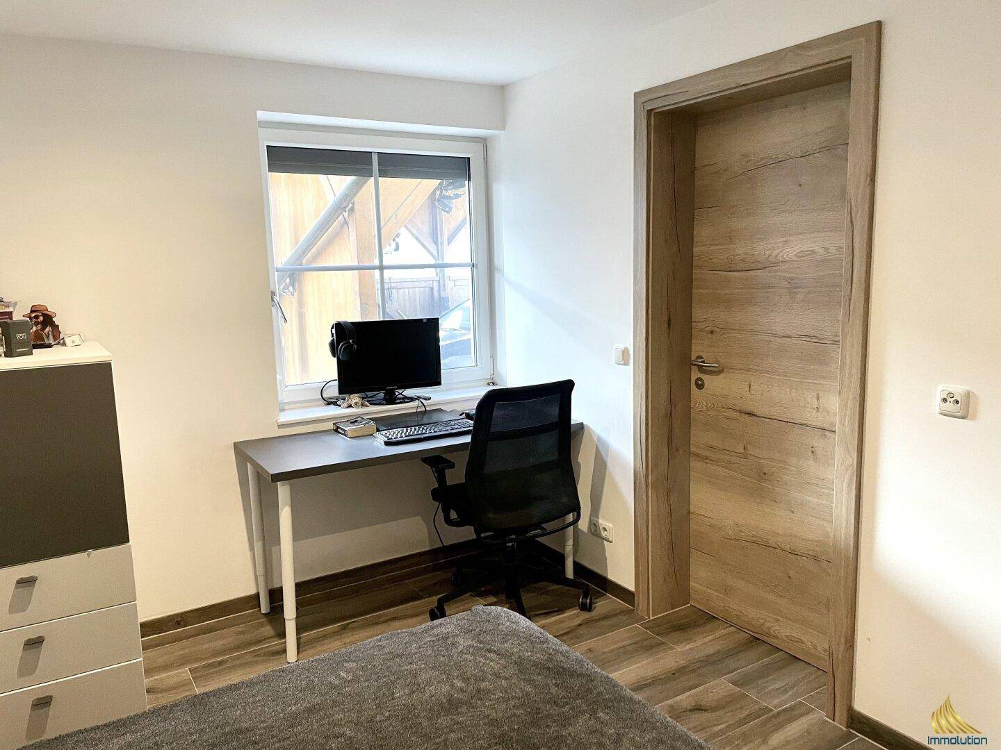Schlafzimmer mit Arbeitsbereich am Fenster, ideal für Home-Office oder Studium, mit viel natürlichem Licht.