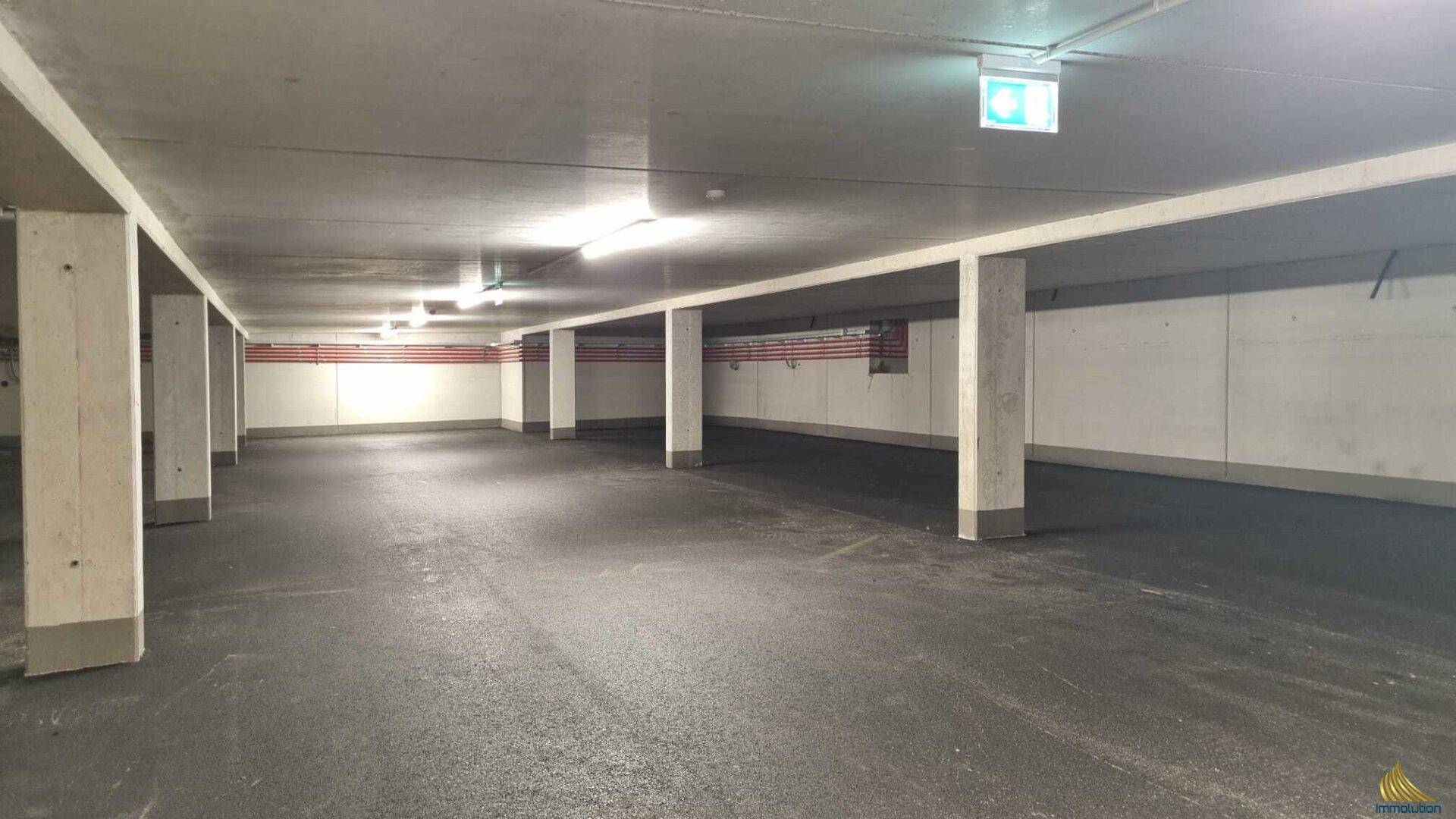 Geräumige Tiefgarage mit Betonstützen und ausreichend Platz für Fahrzeuge.