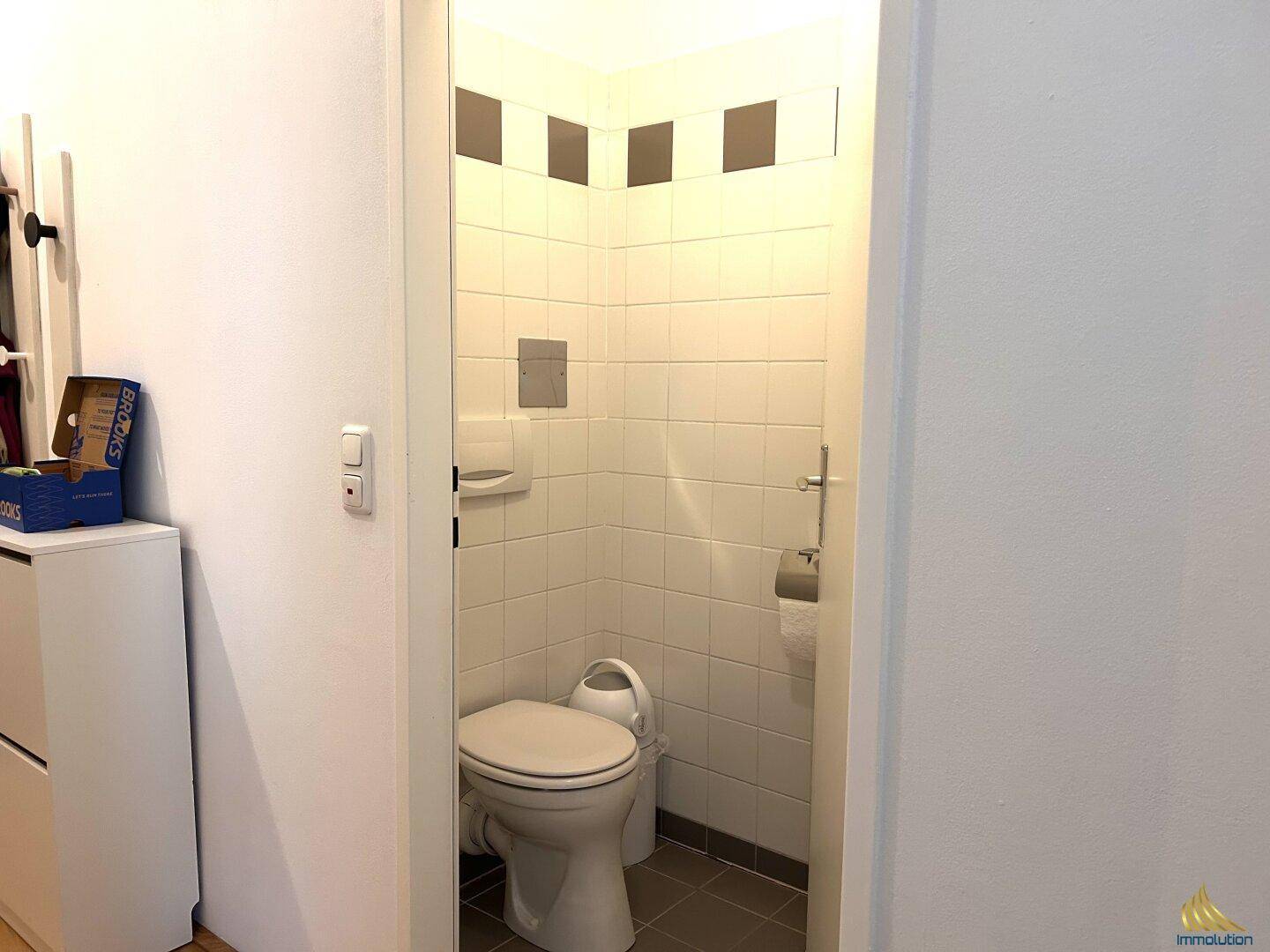 Kleines separates WC mit Fliesen an Wänden und Boden.