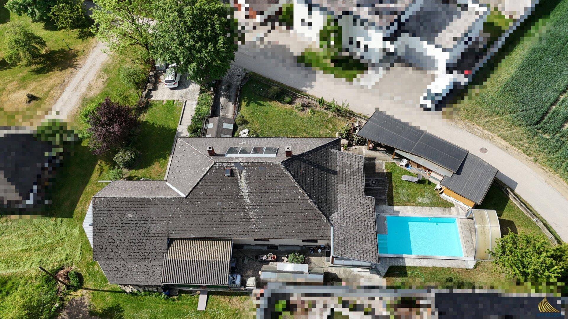 Dachansicht des Hauses mit großem Poolbereich und umliegender grüner Landschaft.