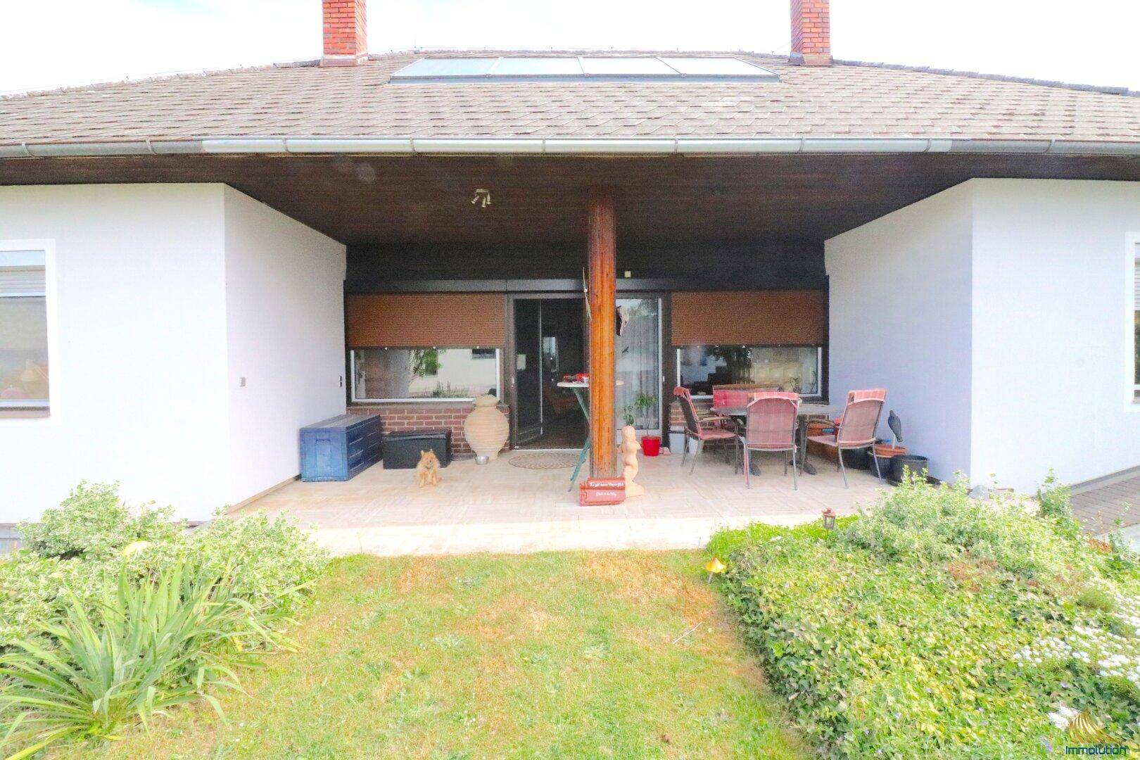 Überdachte Terrasse mit Gartenmöbeln, ideal für entspannte Stunden im Freien.