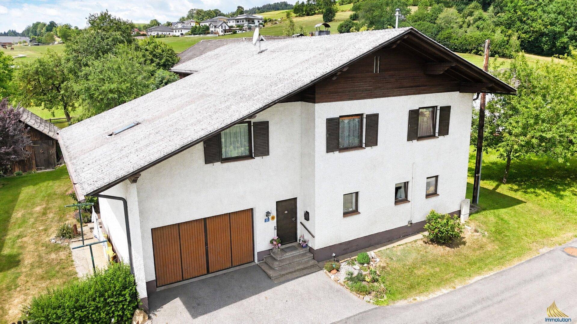 Ansicht des Einfamilienhauses von der Straßenseite mit Garage und Zufahrt.