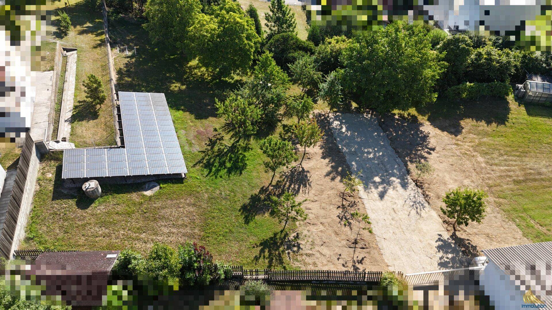 Weitläufiges Grundstück mit Photovoltaikanlage und verschiedenen Vegetationsbereichen.